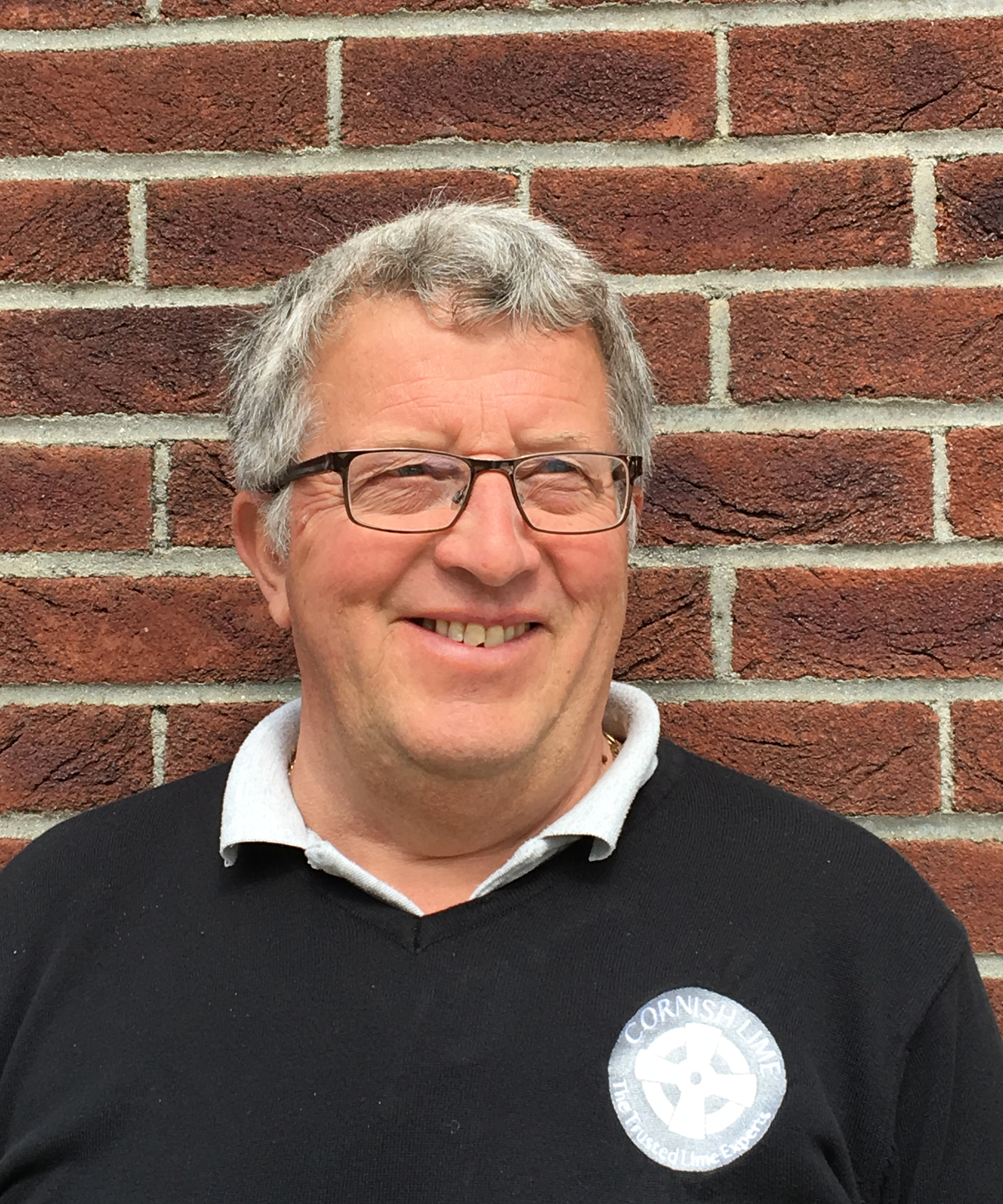 headshot of male with grey hair and glasses