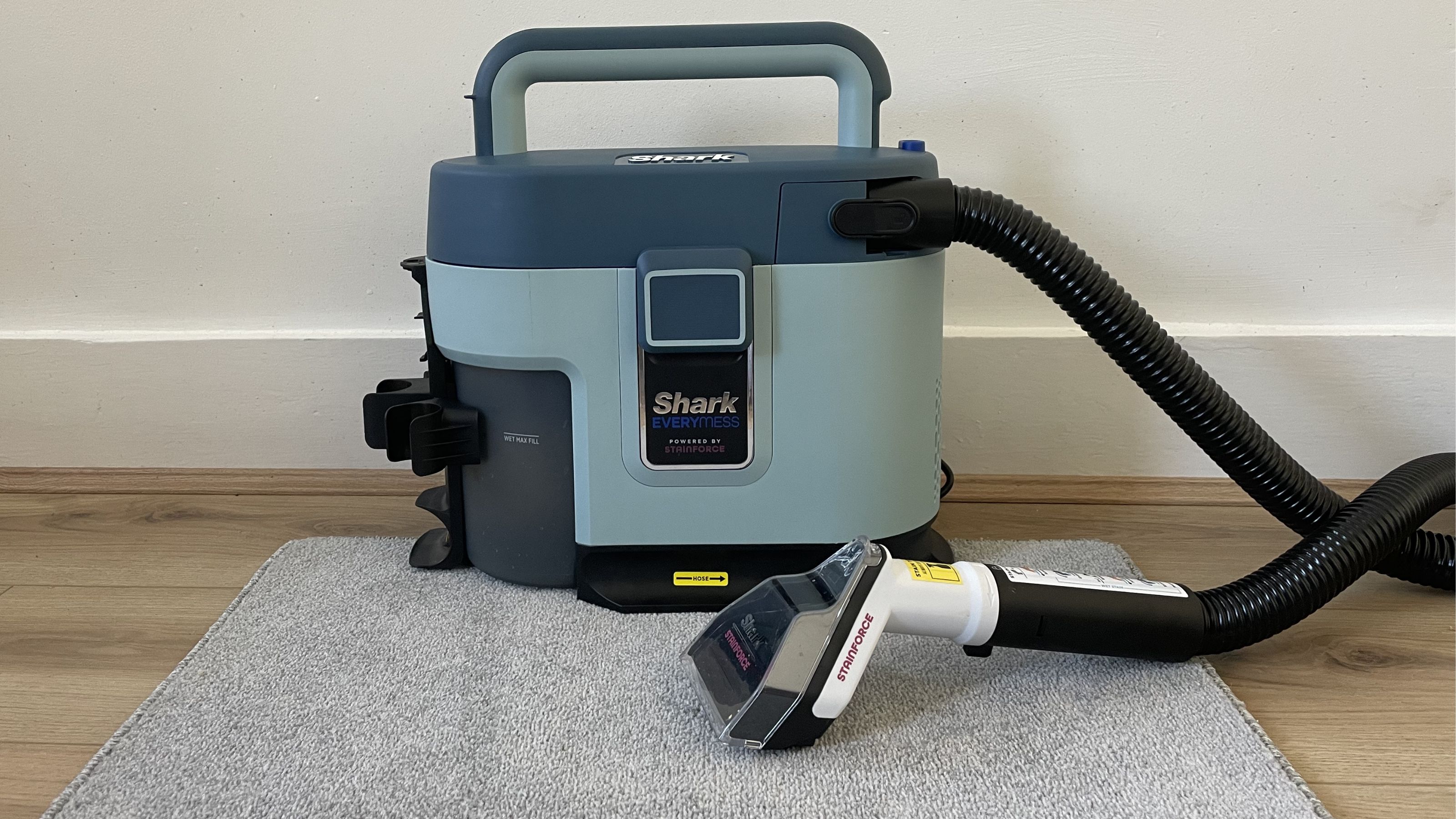 Shark EveryMess sitting on a grey carpet sample