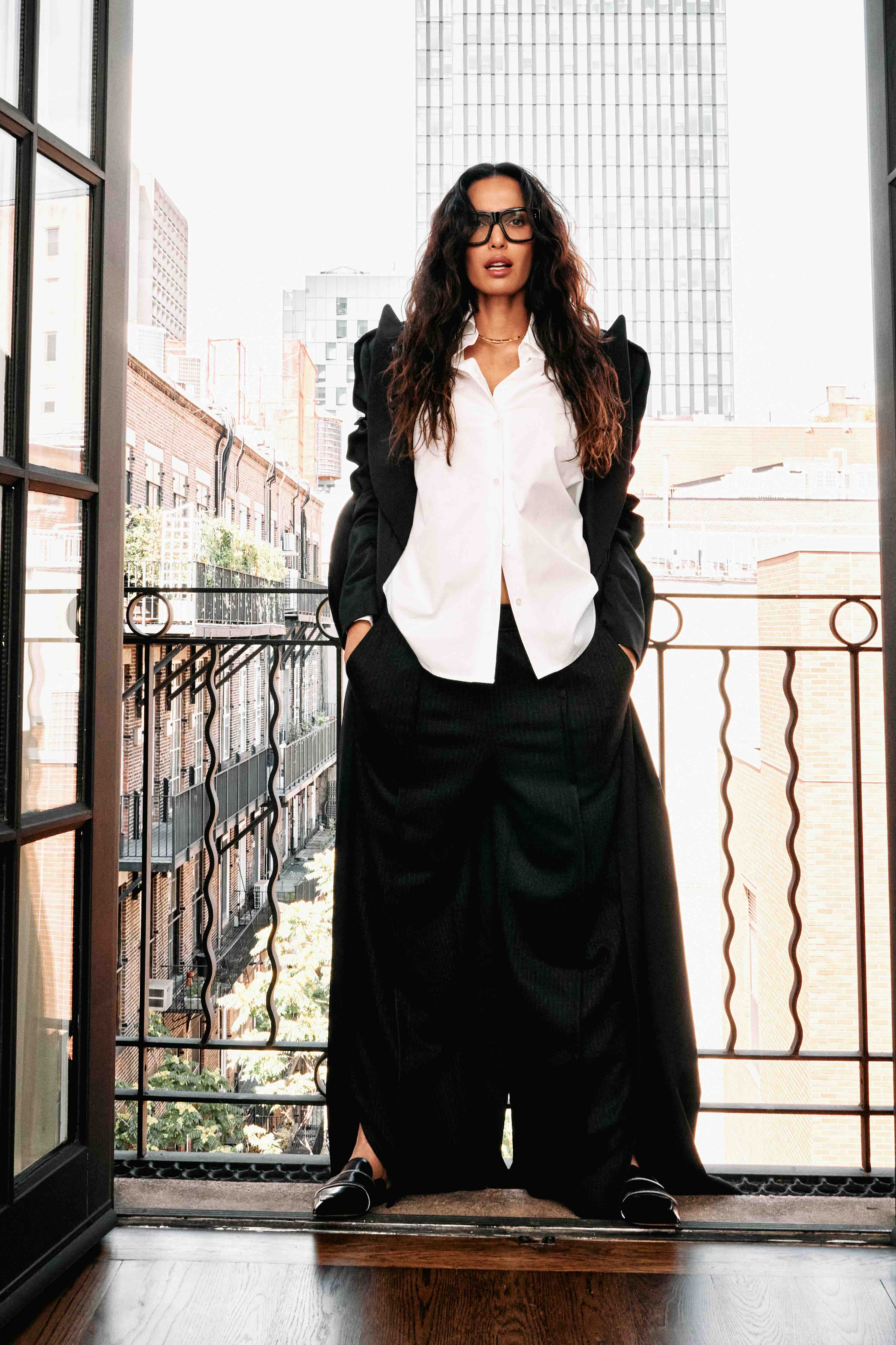Padma Lakshmi poses in front of a window