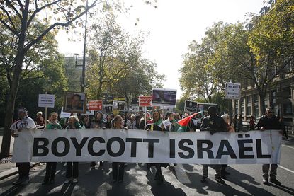 Protestors with boycott Israel sign.