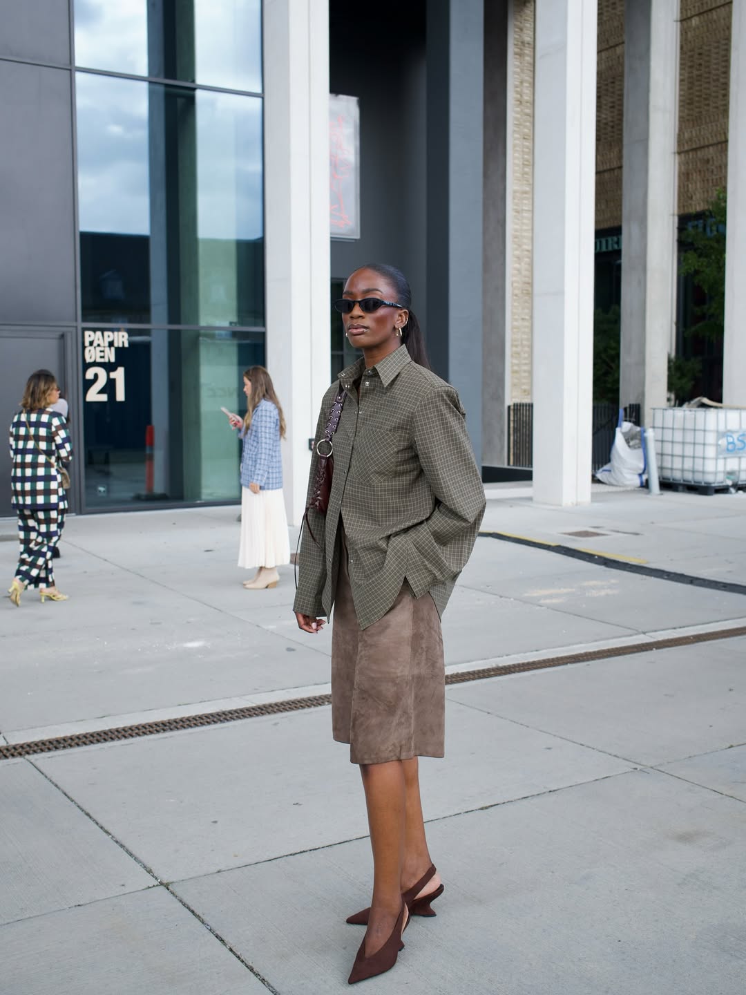 Liv in brown suede shorts and wedge heels