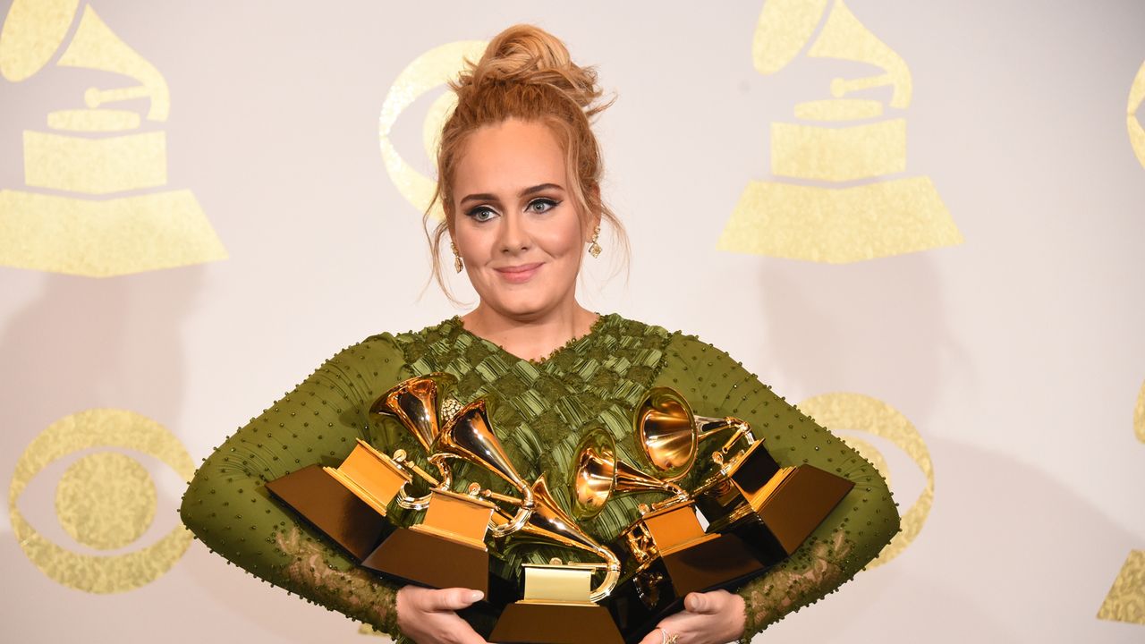 Adele cradles her bundle of Grammy&#039;s won for her singing career