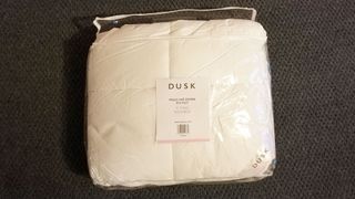 Dusk Feels Like Down duvet in plastic bag, on a carpet