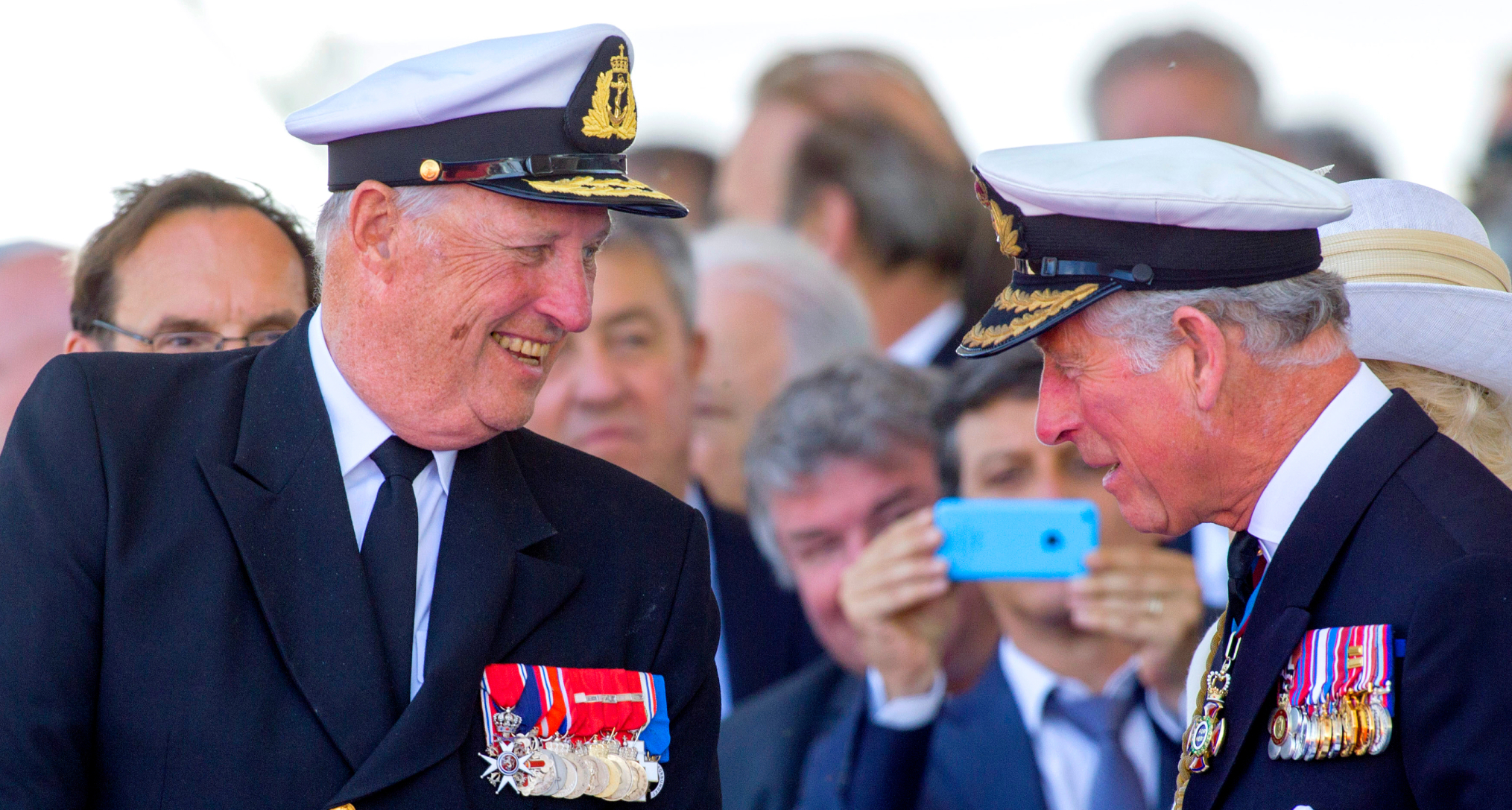 King Harald and King Charles laughing in military uniforms 