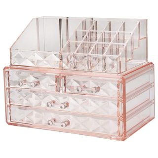 A pink acrylic makeup organizer features numerous drawers for makeup