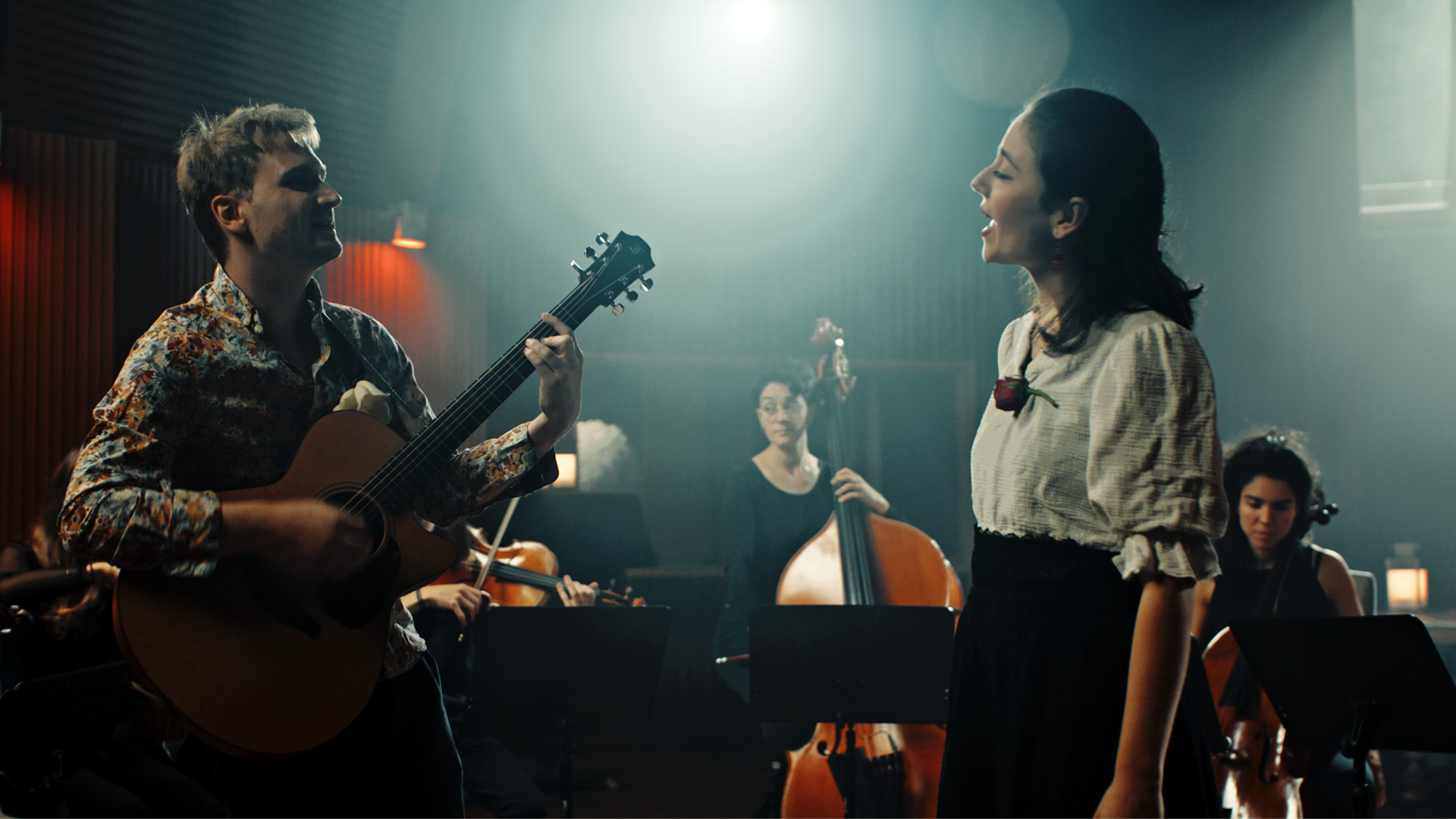Composer Lorien Testard plays guitar while vocalist Alice Duport-Percier sings in a live performance of Clair Obscur: Expedition 33's music