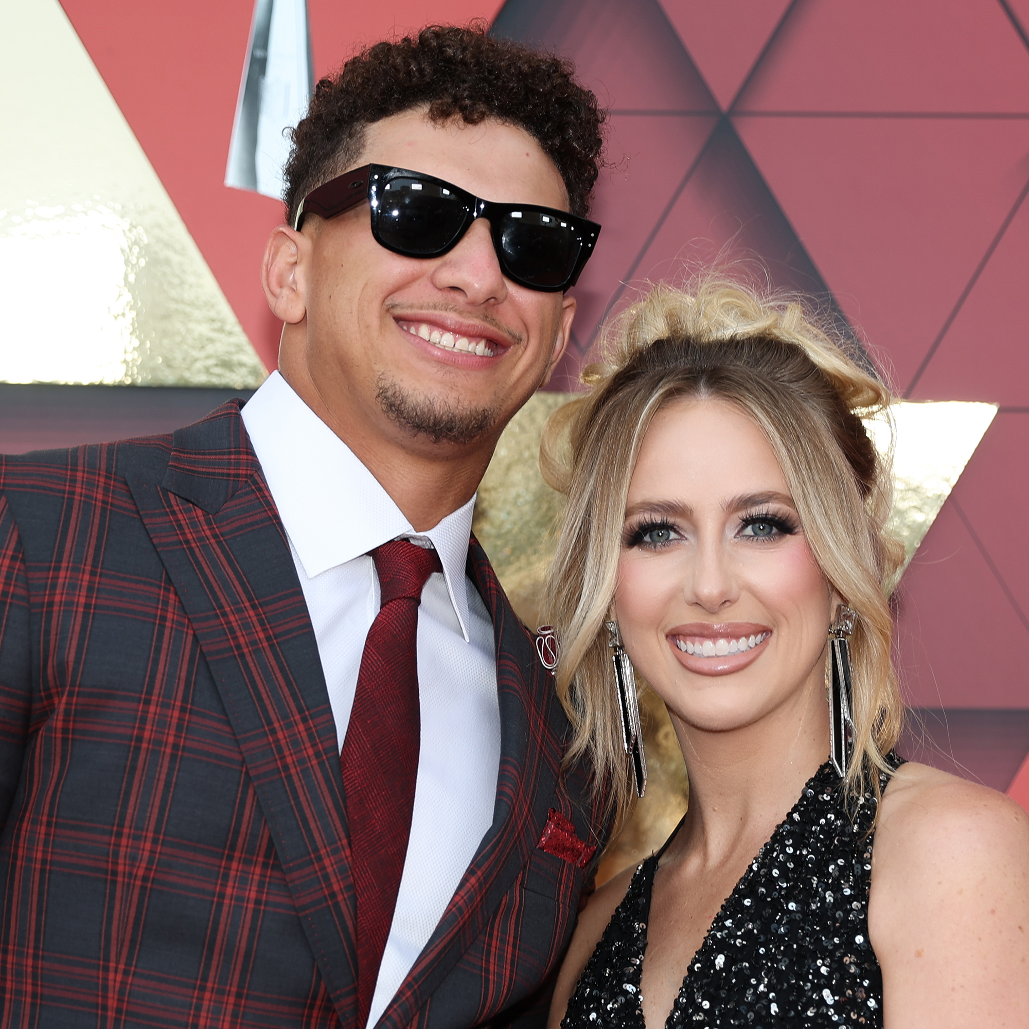 Patrick Mahomes and wife, Brittany, on the Red Carpet in front of a burgundy backdrop before the Super Bowl Championship Ring Ceremony