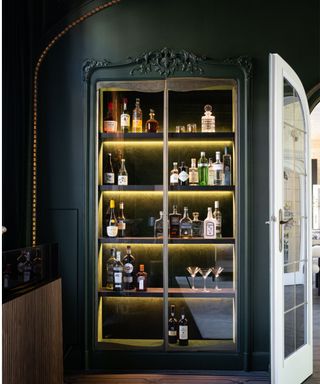 Dark green ornate glass bar cabinet with led lights and bottles