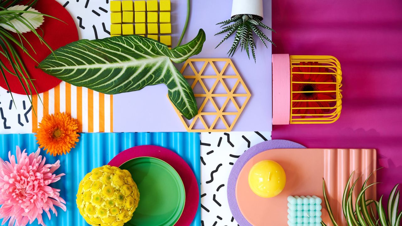 Bold and colorful flatlay of flowers, ceramics and candles