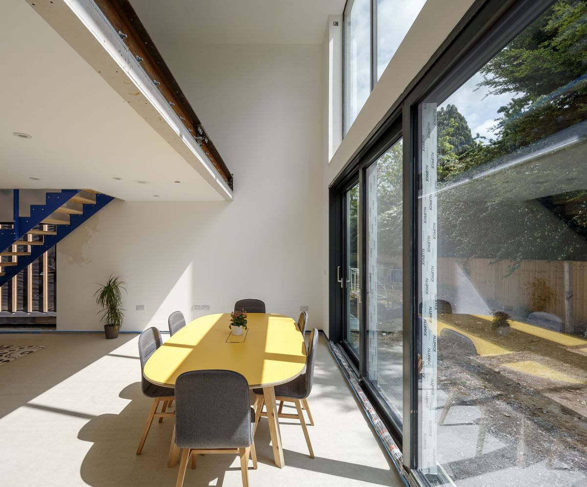 The dining room is next to the bifold windows which shine onto the dining table