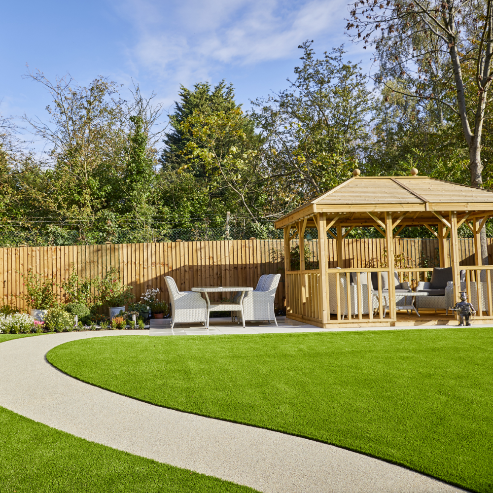 garden with wooden fence white chair and green lawn