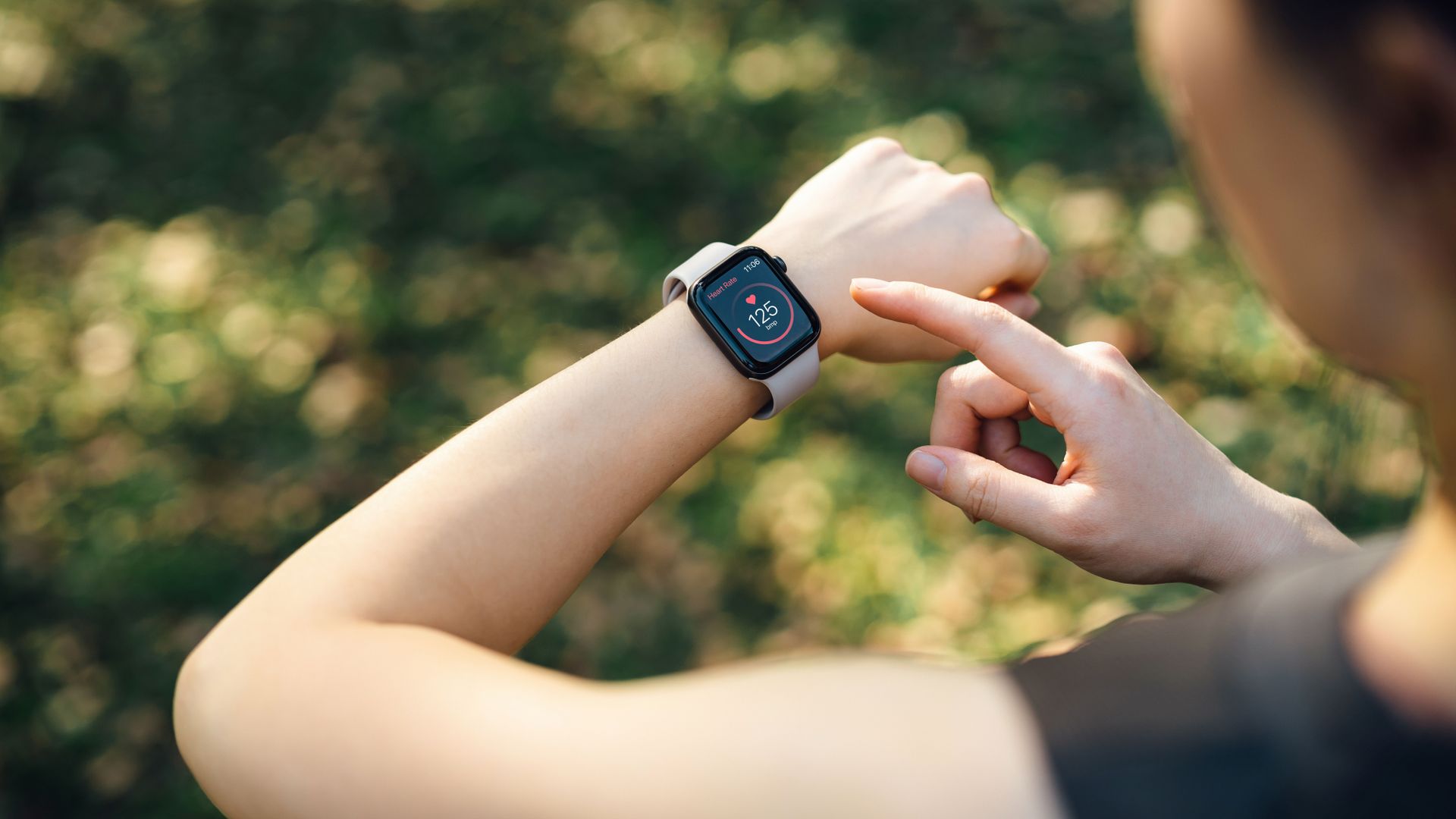 Woman looking at heart rate on fitness tracker watch