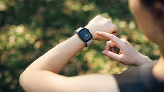 Woman looking at heart rate on fitness tracker watch