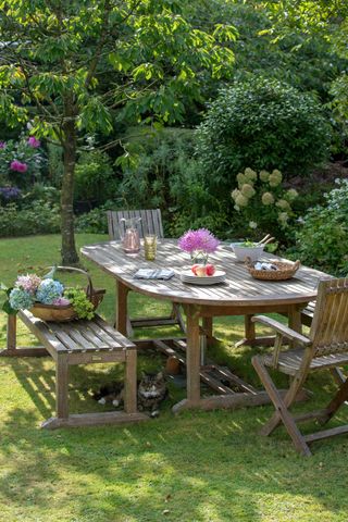 wooden table with cut flowers on lawn for budget backyard ideas