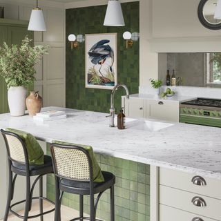 Kitchen with large island with green square tiles on front matching green square tiles on wall