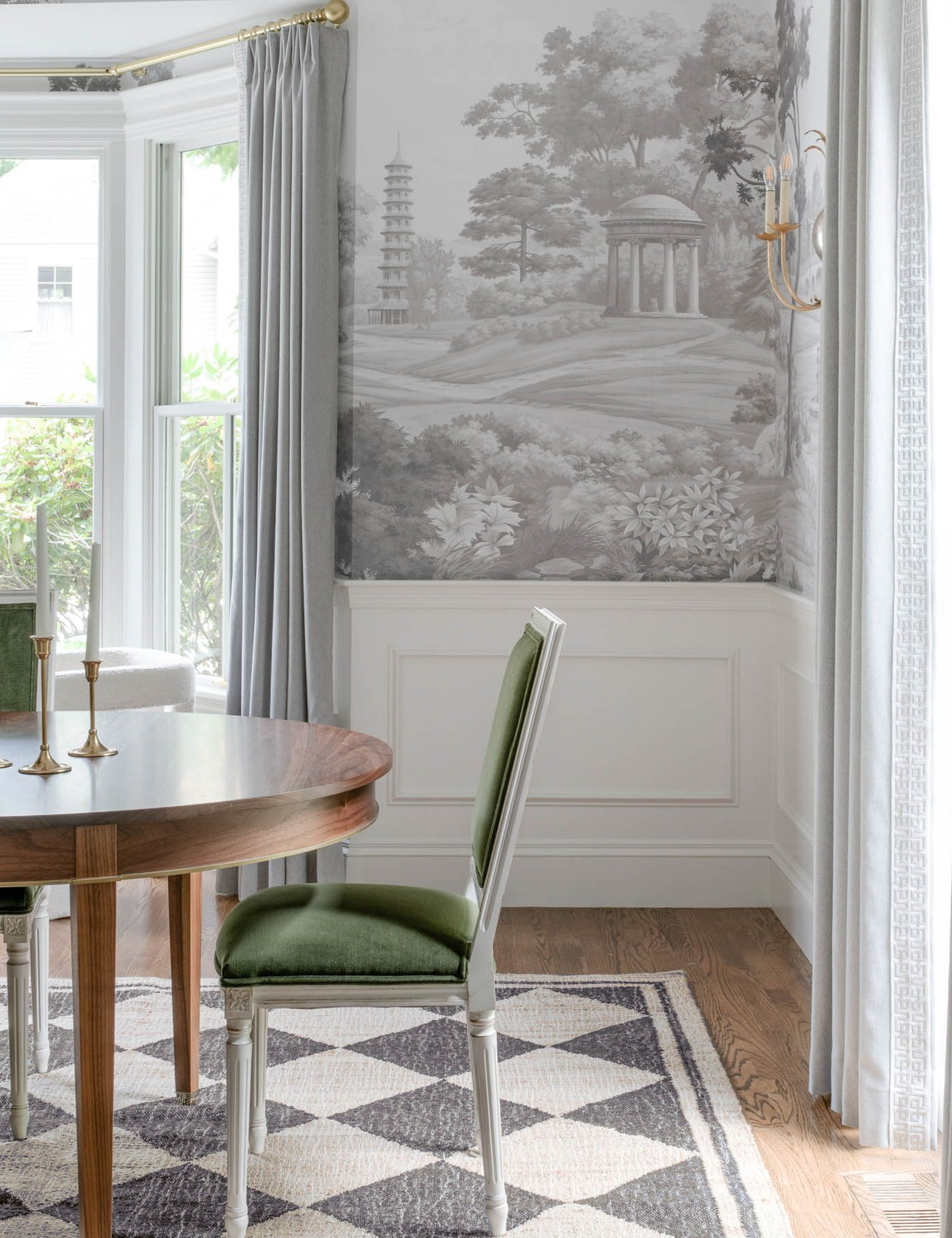 Black-and-white harlequin rug featured in a classically styled dining room with toile wallpaper