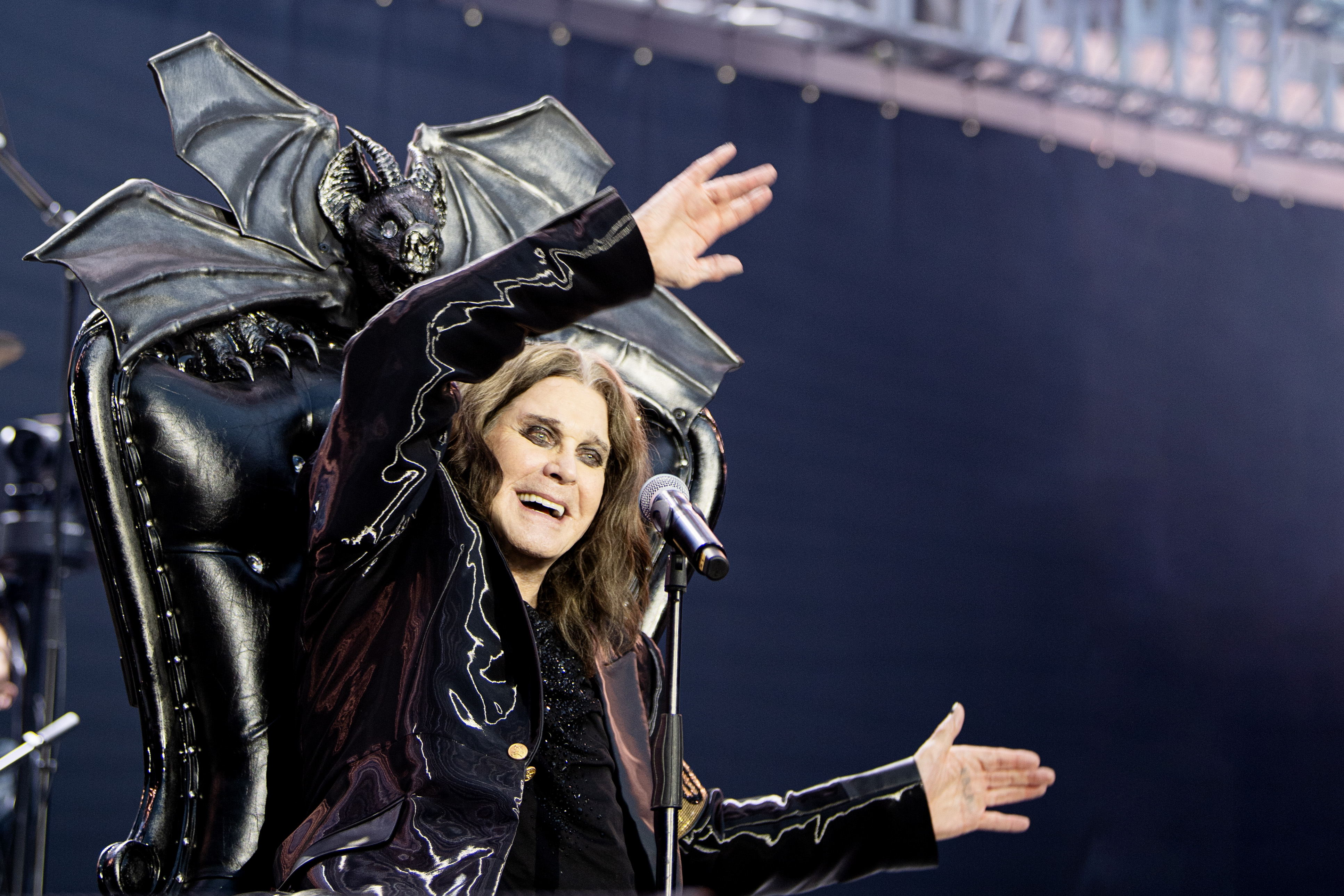 Ozzy Osbourne waving his arms on stage