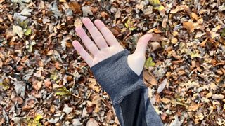 Icebreaker 260 ZoneKnit Long Sleeve Half Zip Thermal Top closeup of hand using thumbloop, against leafy background