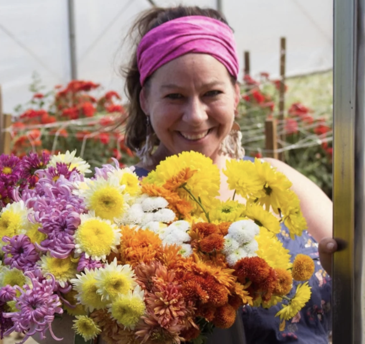 Woman holding huge bunches of chrysanthemums