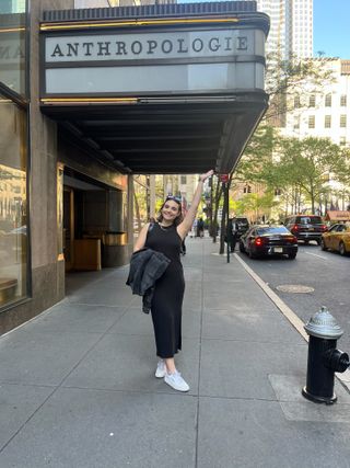 woman stands outside an anthropologie store