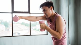 Man shadow boxing with dumbbells