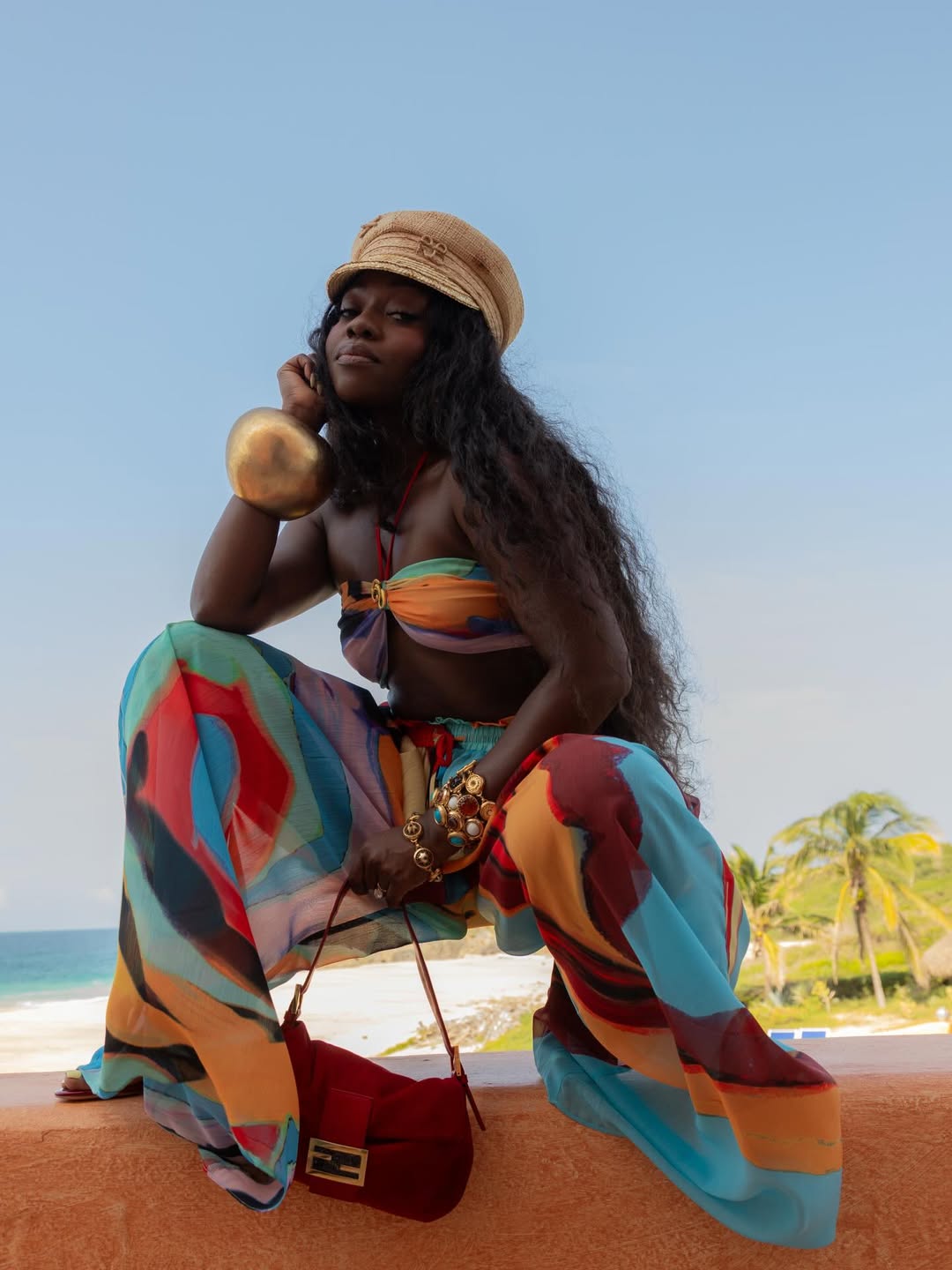 Fisayo Longe wears layered jewellery colourful trousers