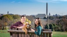 Young couple Daniel Bortz and his wife, Alexandra, sitting on a park bench overlooking Washington, D.C.