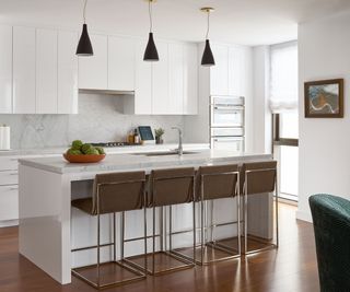 white kitchen with island and four stools