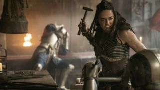 Holga (Michelle Rodriguez) about to smack a soldier with a hammer in Dungeons & Dragons: Honor Among Thieves