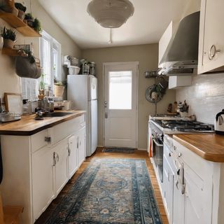 Blue runner rug in kitchen with white cabinets