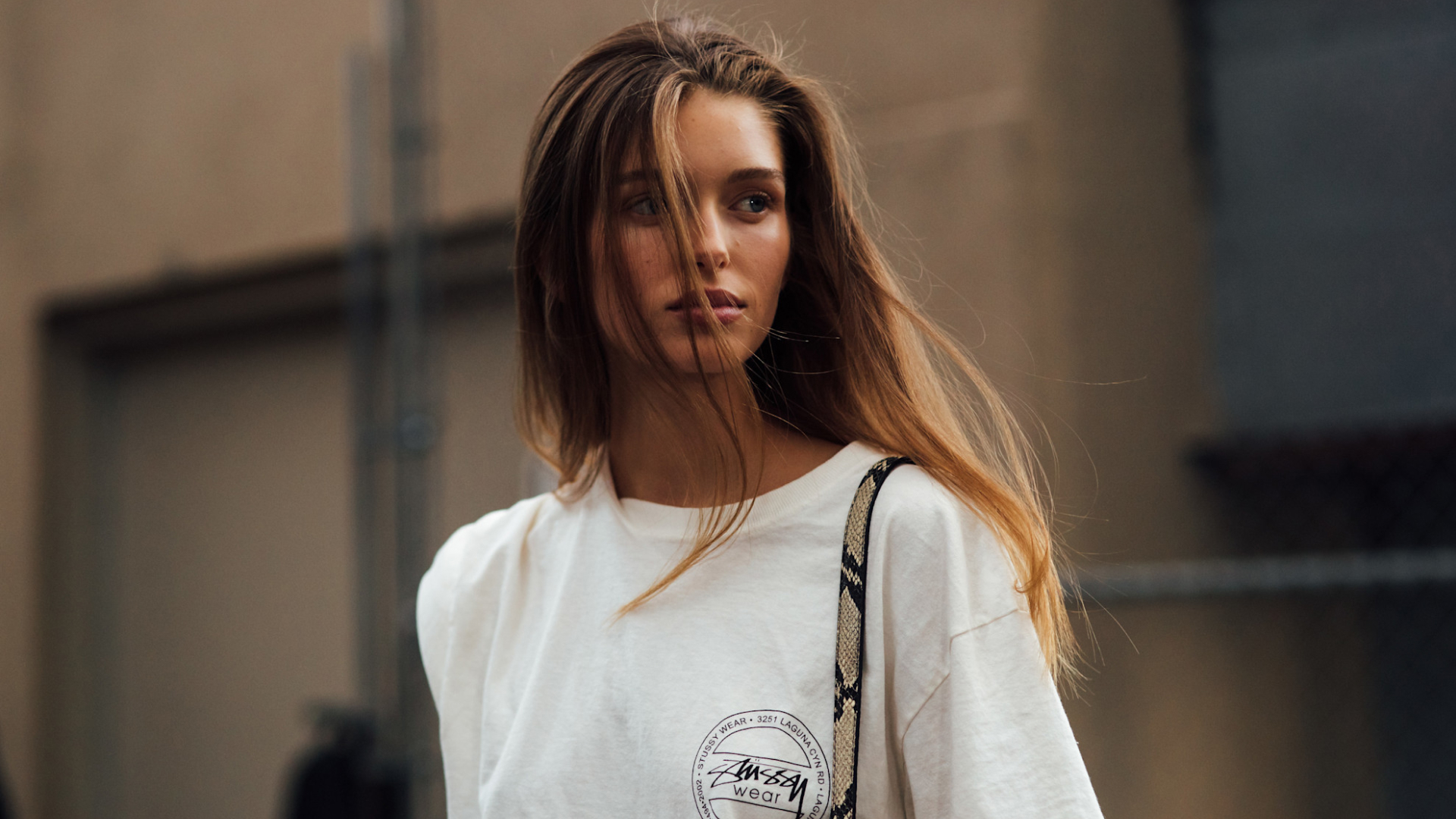 blonde fashion week attendee looking away from camera wearing white top