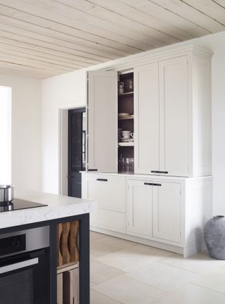 kitchen cabinet with white cabinetry and black island