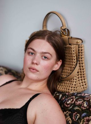 Model leaning on handbag