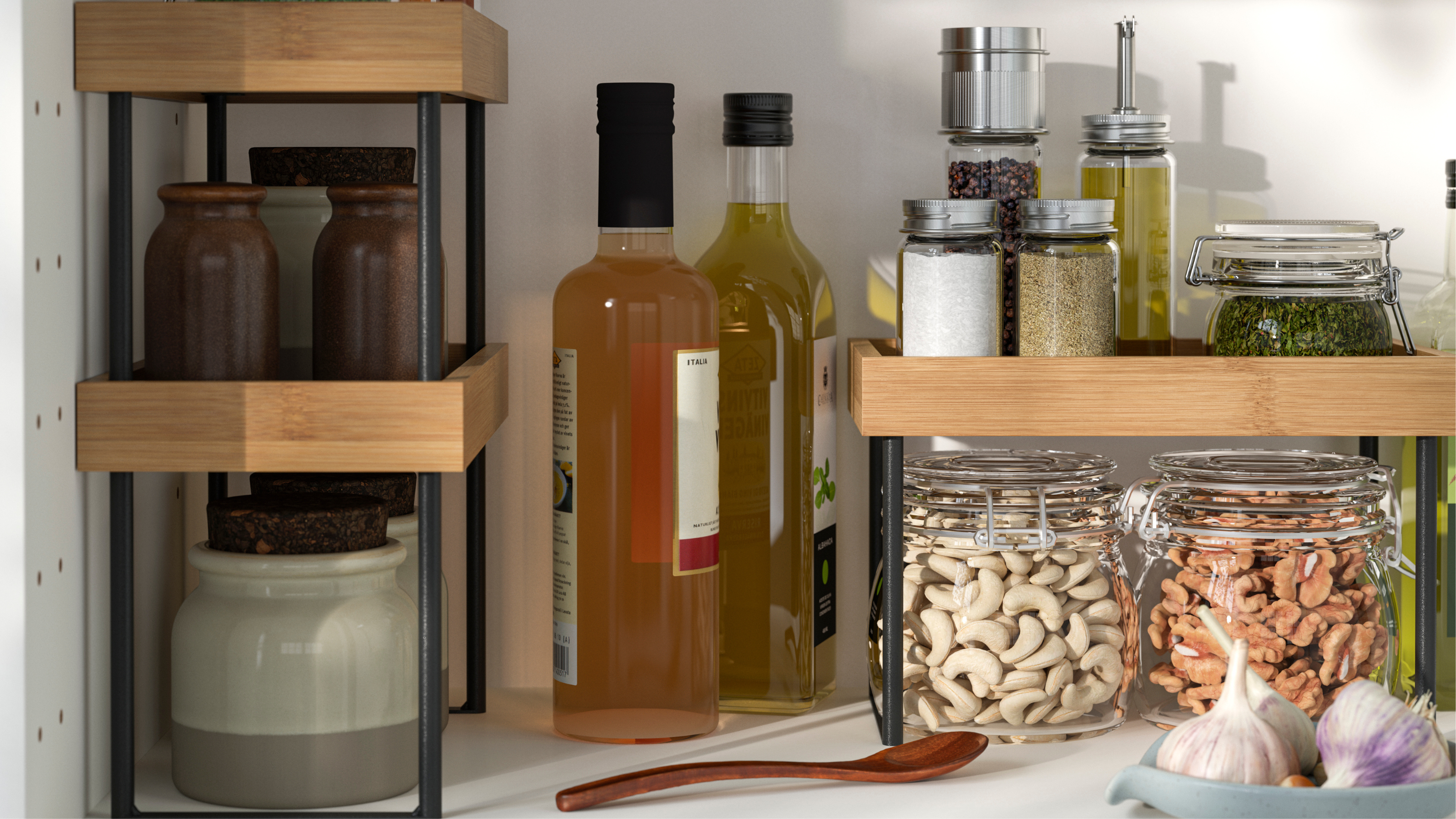 The inside of a white kitchen cupboard with three IKEA nalblecka countertop organizers inside, two stacked on top of one another and one by itself, storing condiments, spices and jars with food and nuts