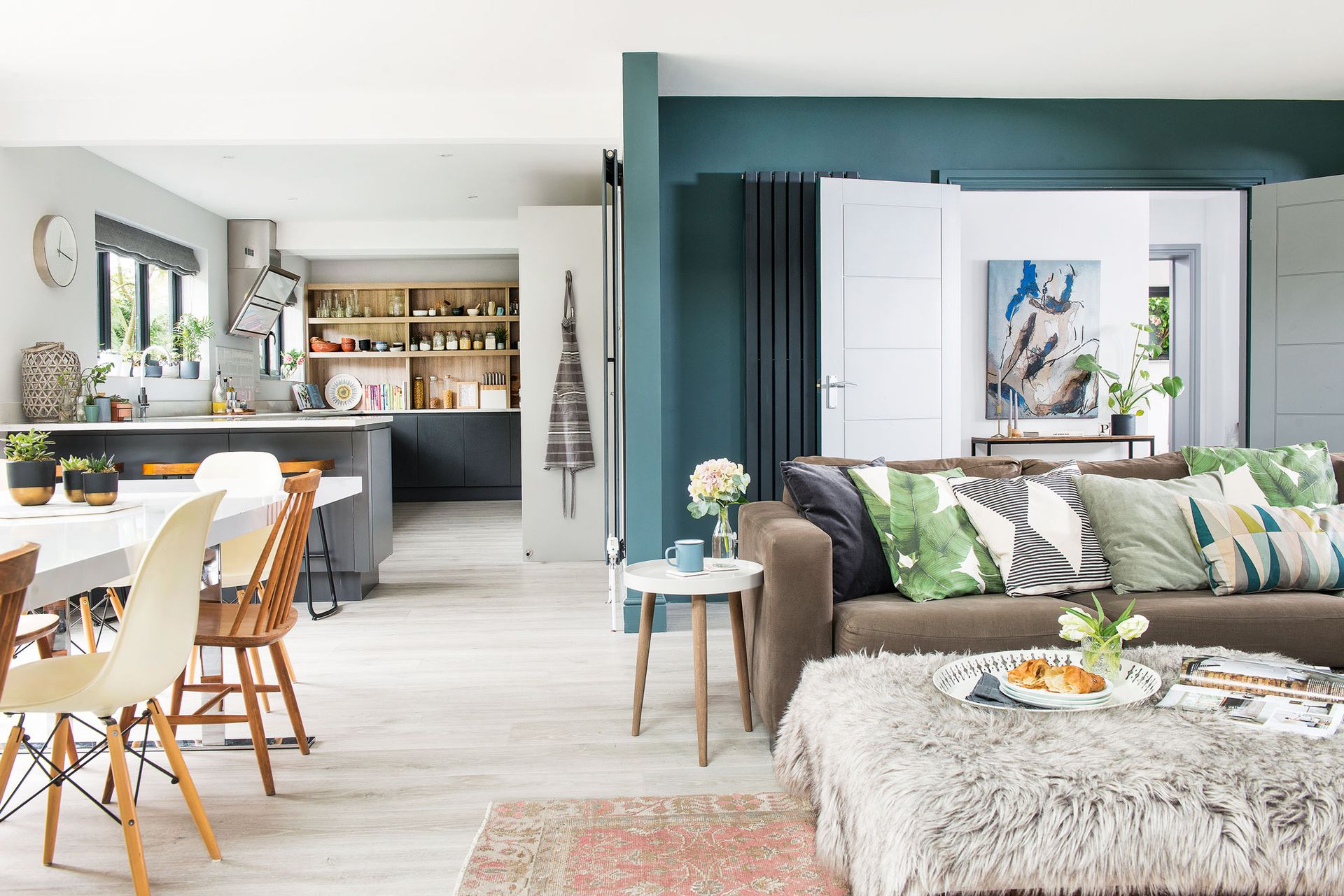 Open plan kitchen and living area with a teal feature wall as an exxmple to show how to declutter your home to keep open plan living tidy