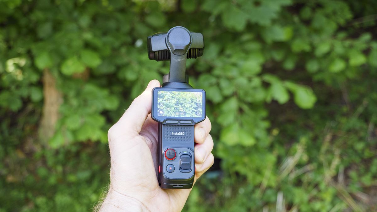 Insta360 Luna Ultra vlogging camera in person's hand, screen rotated and 4K 60p video active, leafy background