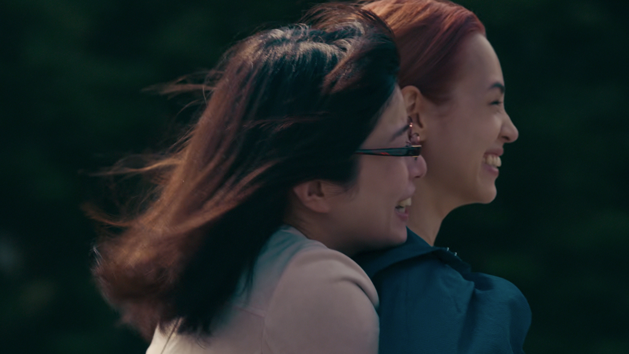 Two women smile with the wind blowing their hair back in Ride or Die