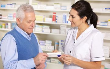 American pharmacist serving senior man in pharmacy