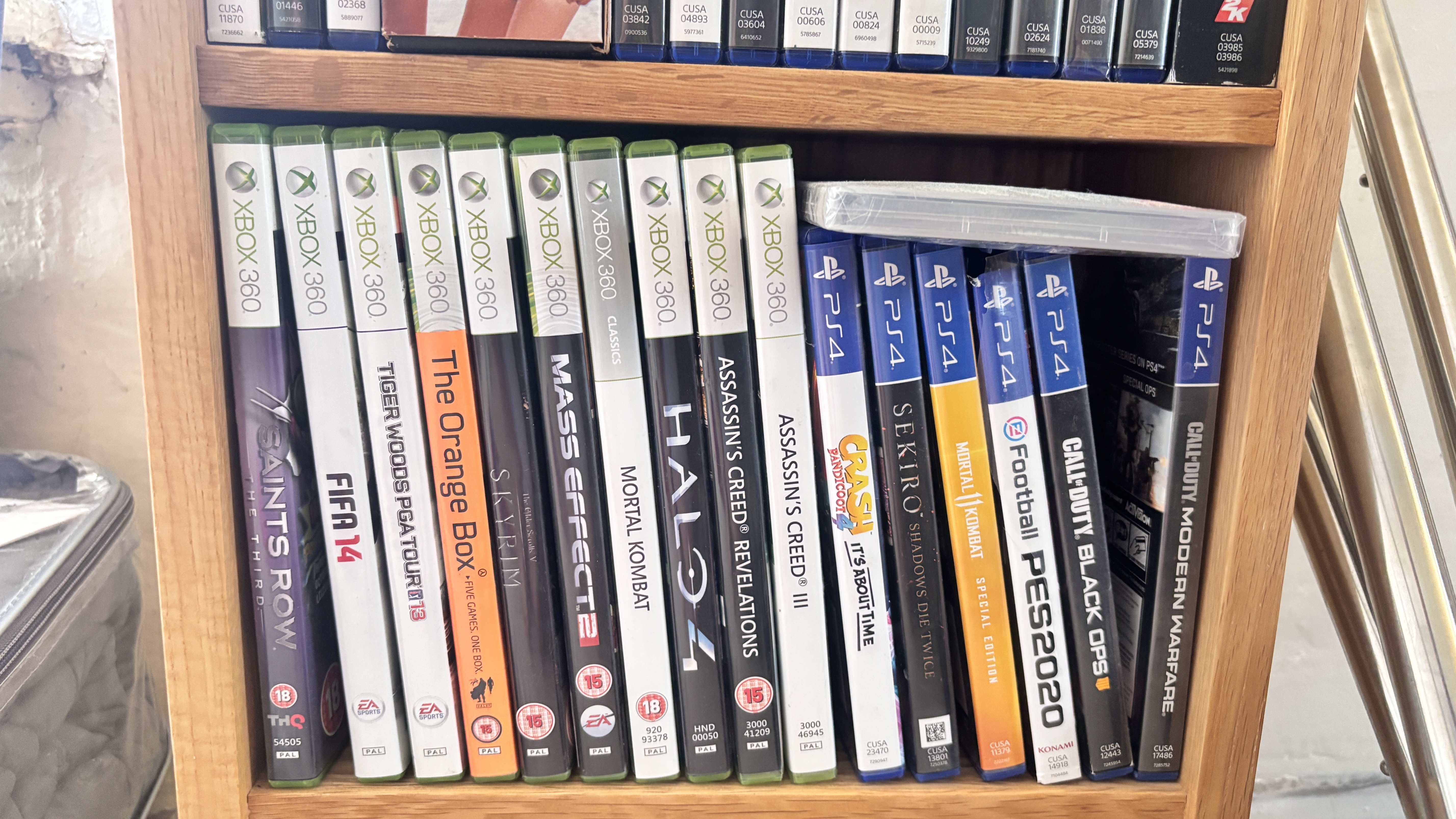 PlayStation 4 and Xbox 360 games held in a wooden bookshelf