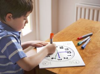 young boy learning to tell the time