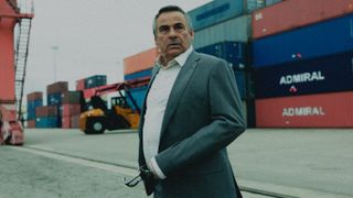 Joaquin (Eduardo Fernandez) in front of shipping containers in Iron Reign episode 1