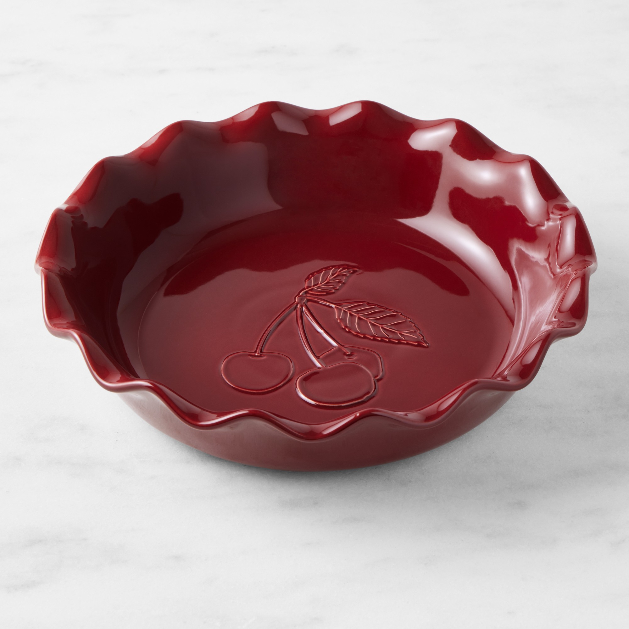 An Emile Henry cherry embossed ruffled pie dish