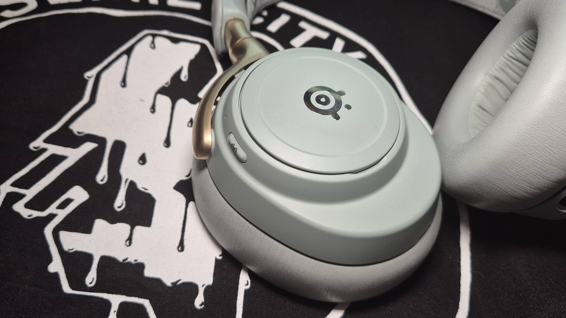 Photo of the SteelSeries Arctis Nova Elite headset resting on a Slime City band tote bag.