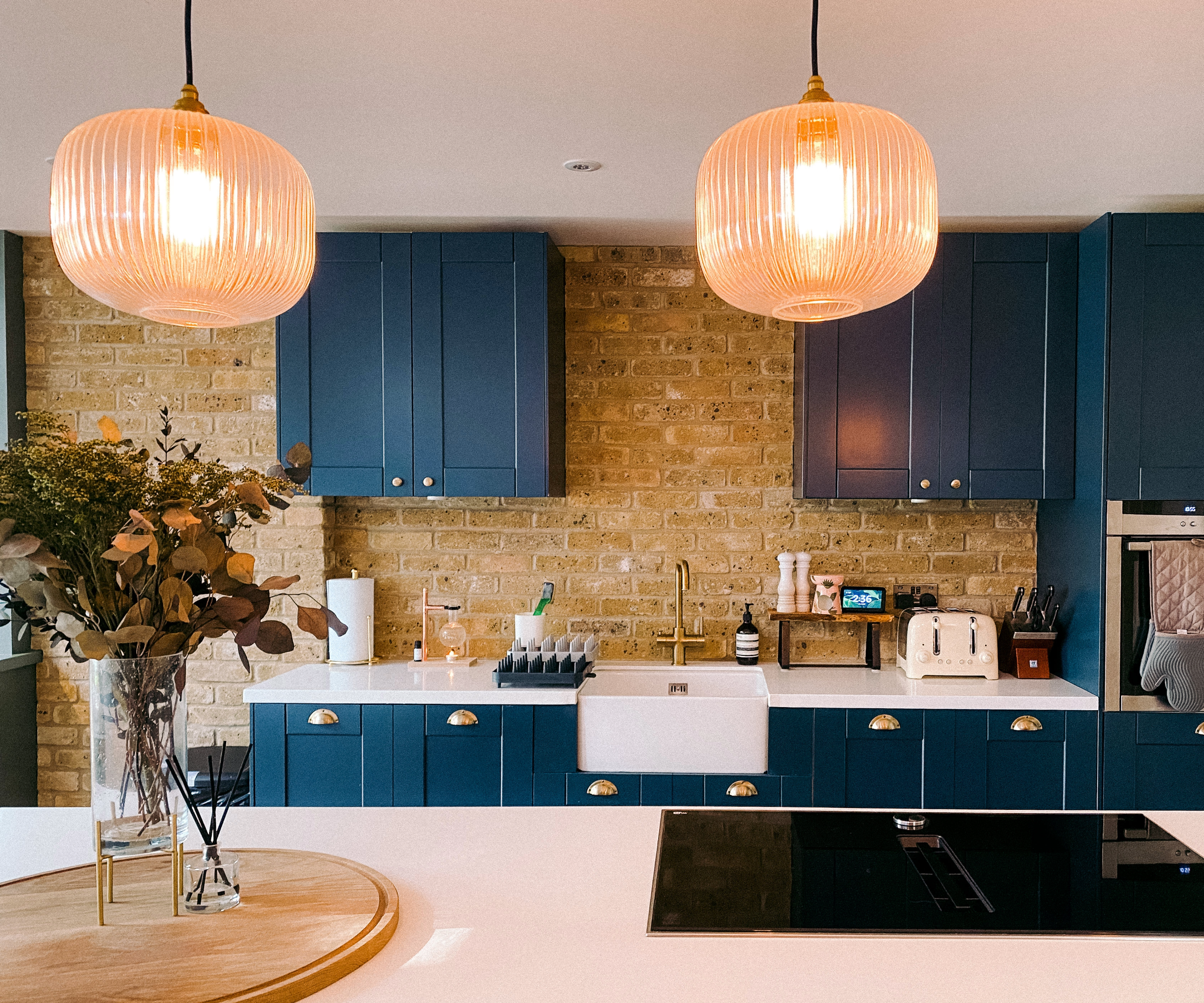 Kitchen with blue cabinets and brick style wall tiling