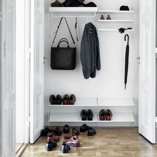 hallway with white modern storage at one end, coats and shoe storage