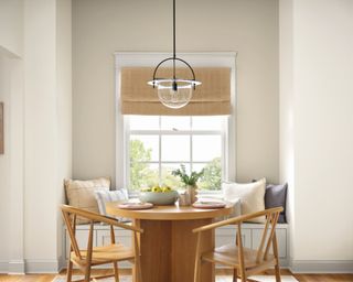 dining room with warm white walls and wooden table and chairs in front of window