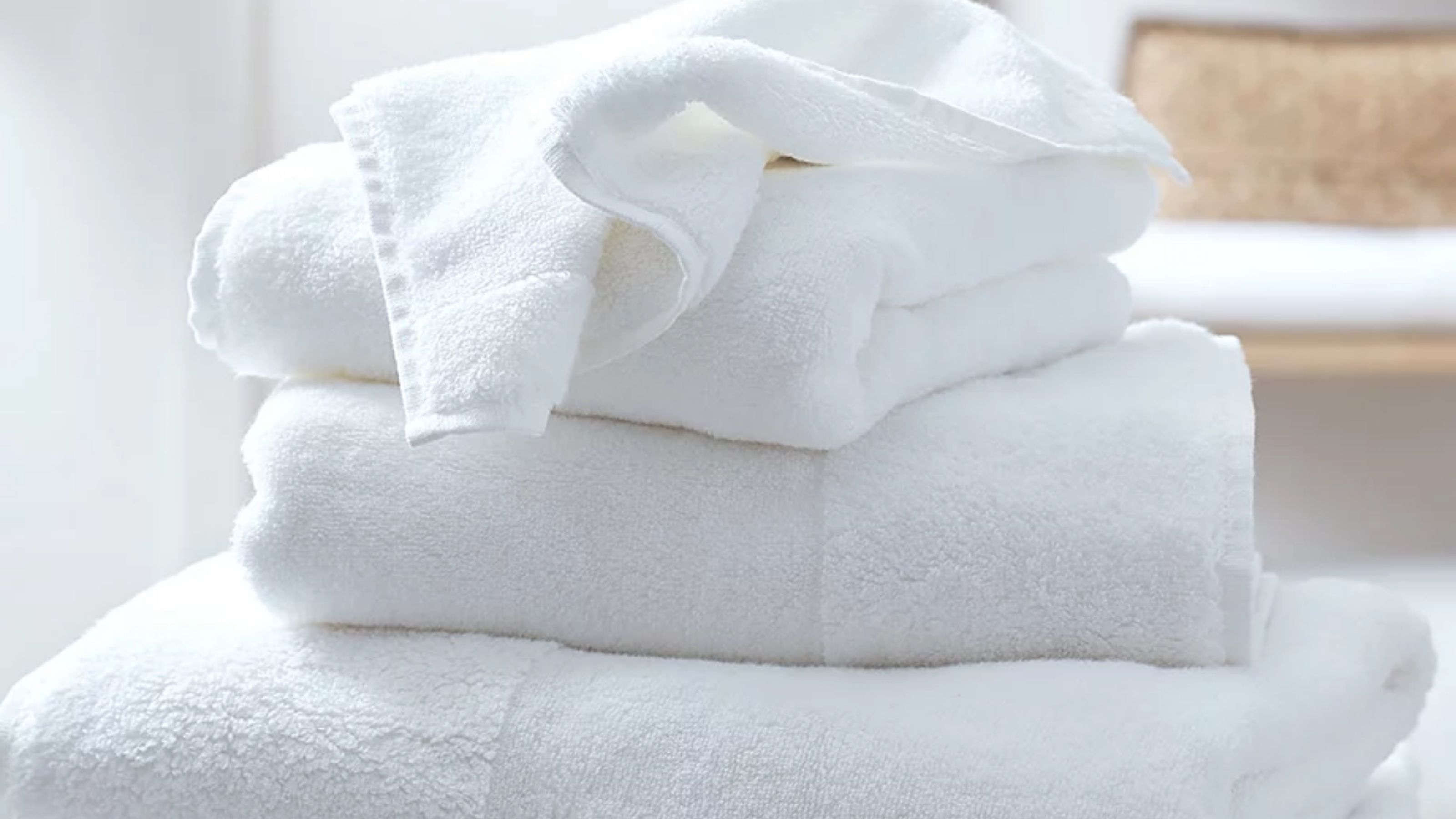 Close-up image of a stack of white towels in a white room.