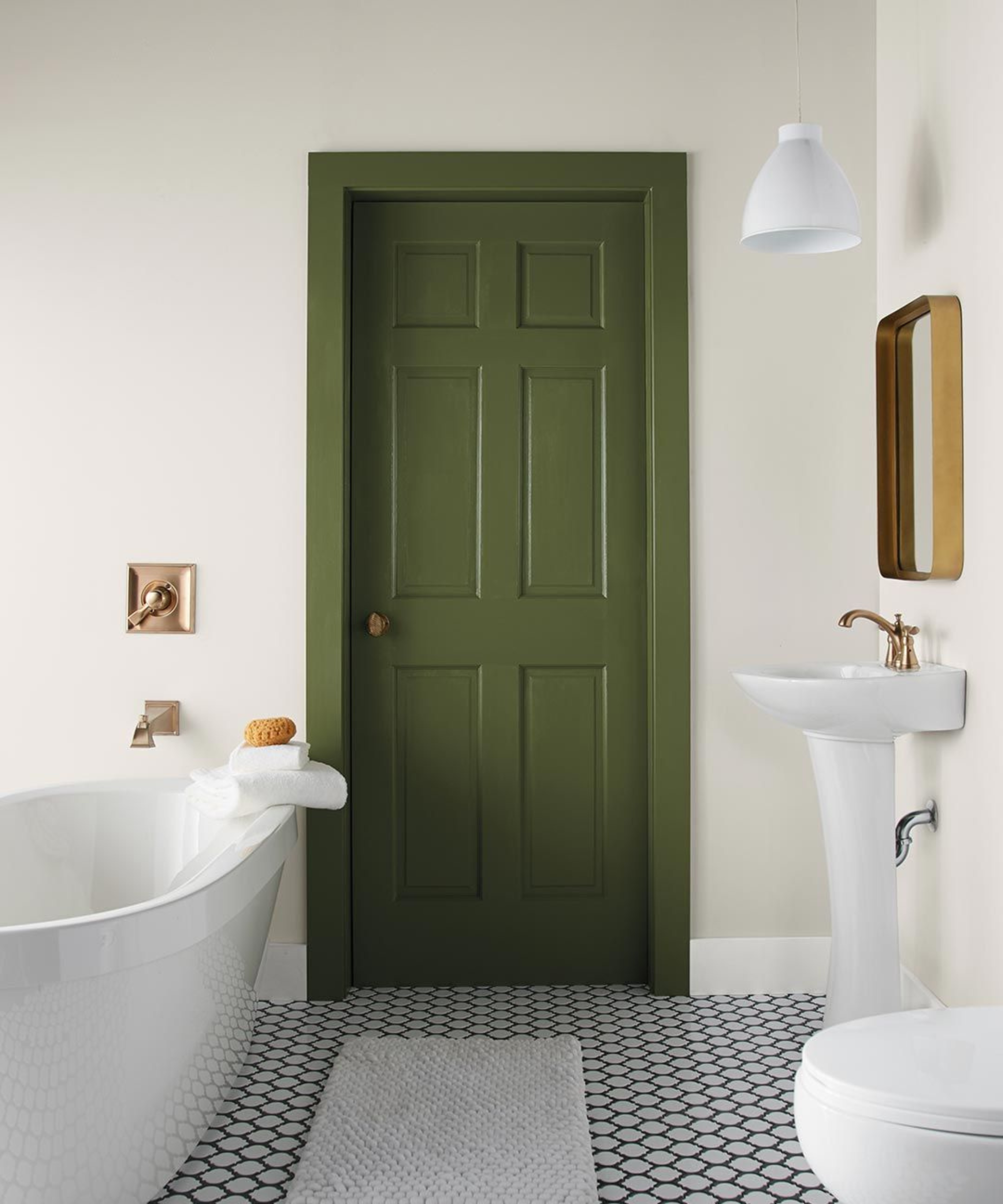 a white bathroom with a tub, a freestanding sink, a tile floor, and a green door