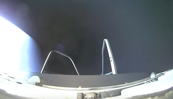 A view down toward a darkened Earth from the spacewalk platform