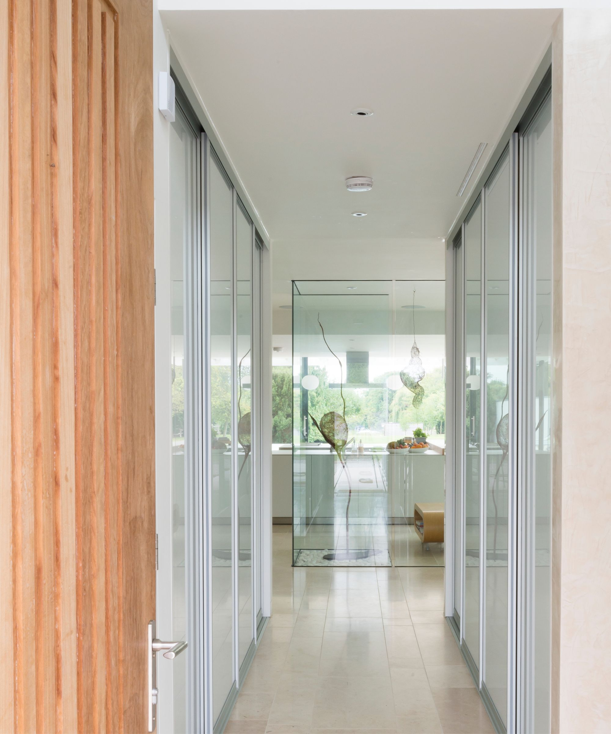 A hallway with glazed elements and a wooden door in the foreground